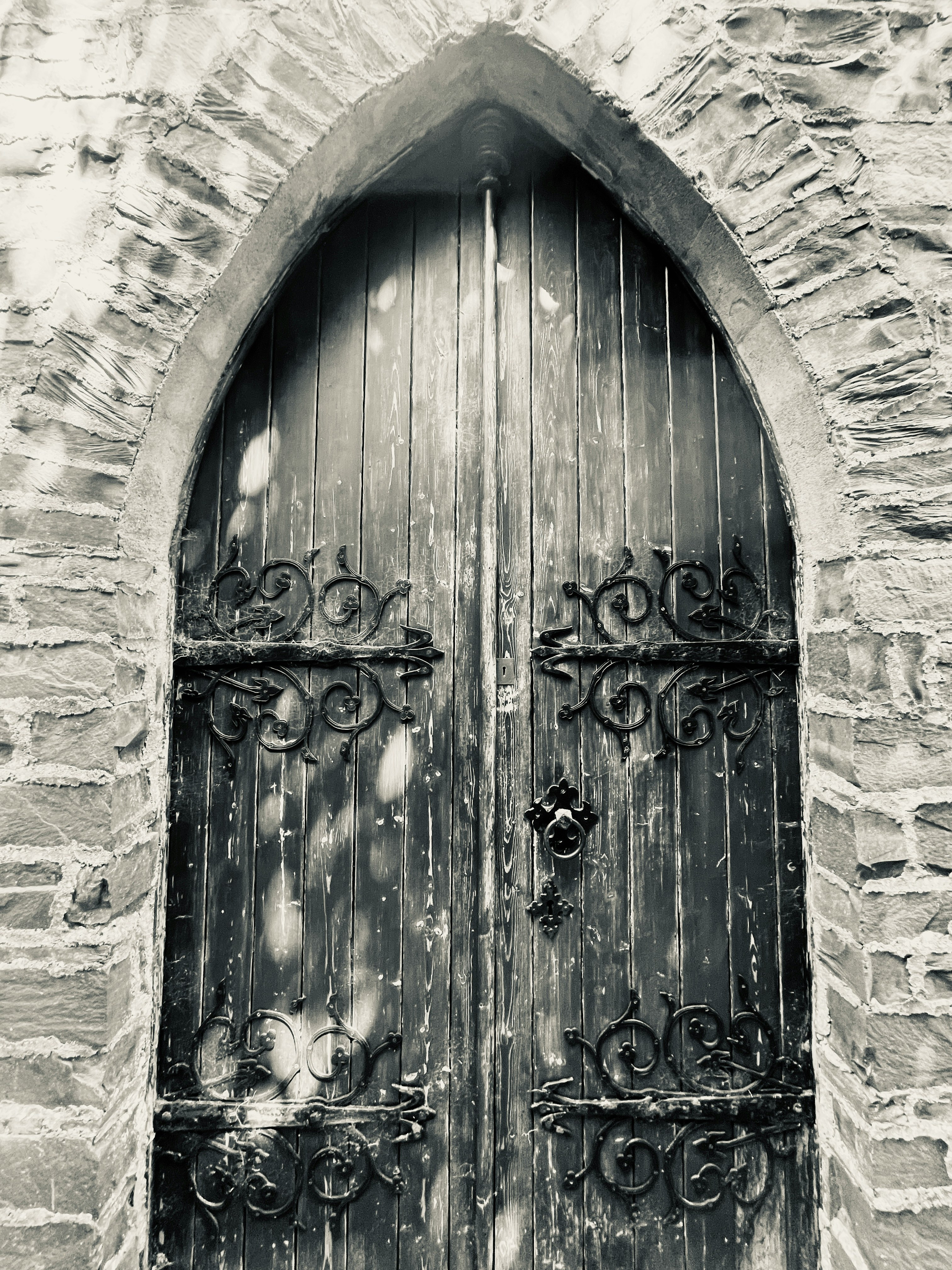 black wooden door with gold floral wreath